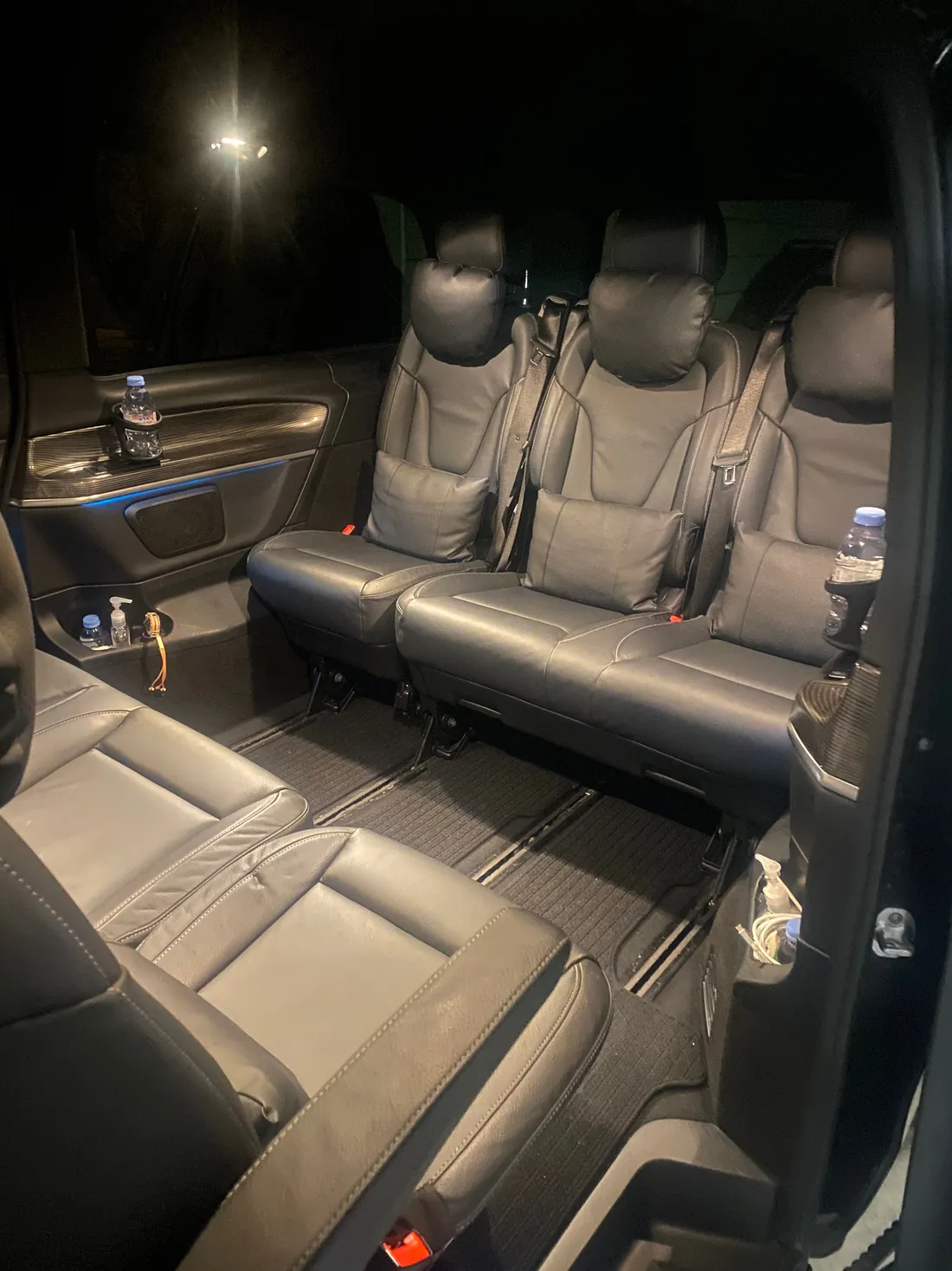 Intérieur du van Mercedes Classe V de Toulouse VTC Pro — banquette arrière en cuir noir et sièges en vis-à-vis, éclairage d’ambiance